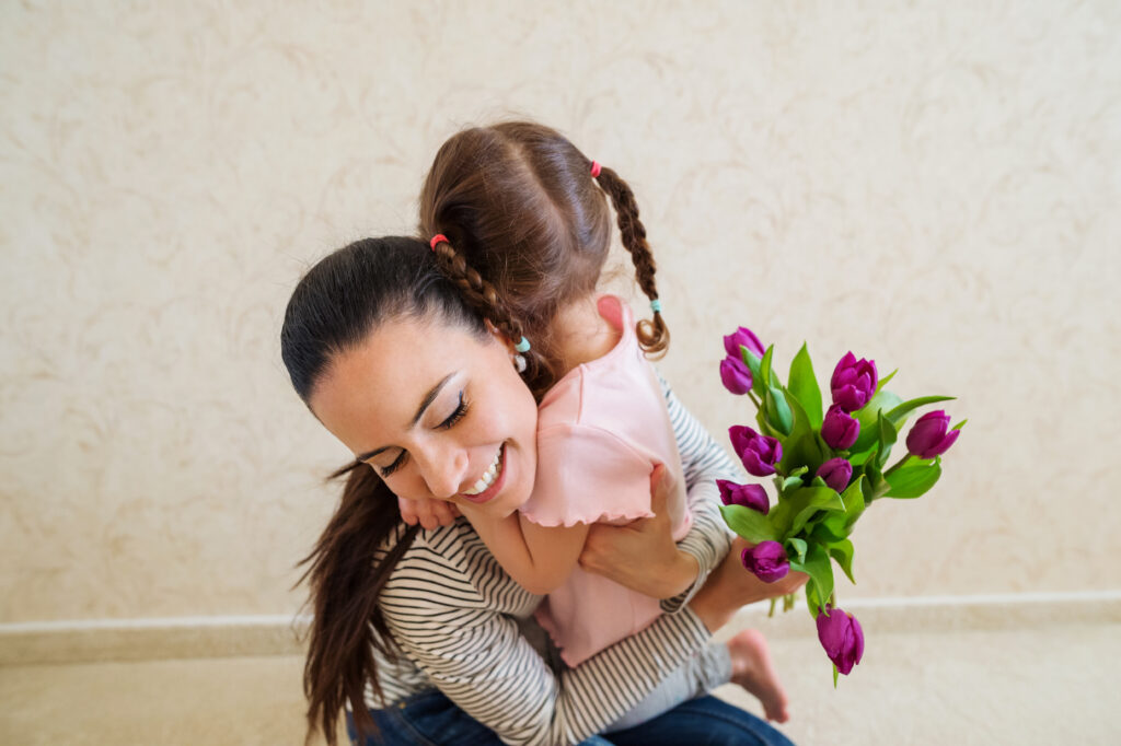 Mothers day, little girl giving flowers to her mum