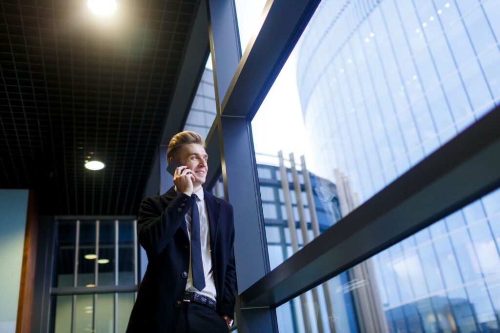 storyblocks-businessman-communicating-on-cellphone-by-window-of-office-center_SIgjWZIvA-