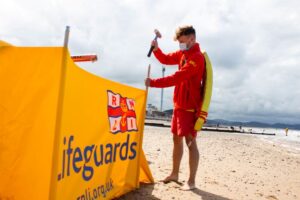 Rhyl-RNLI-Lifeguard-putting-up-windbreak