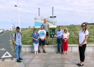 Representatives-from-J.G.-Hale-Construction-and-Tai-Tarian-with-the-defibrillator-campaign-organisers-at-the-newly-installed-defibrillator-on-Aberavon-seafront.