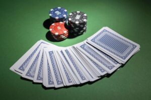 casino-tokens-on-green-background-with-deck-of-cards-free-photo