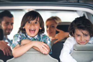 sm-two-cheerful-kids-on-a-car-backseat-SBI-300992126