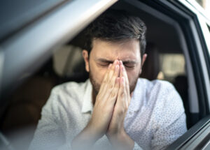 Driver blowing his nose at car