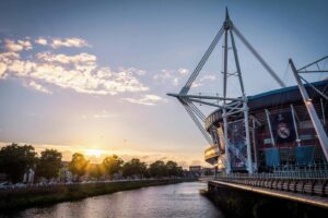 Scenic view of Principality Stadium by River Taff in Cardiff, Wales during sunset.