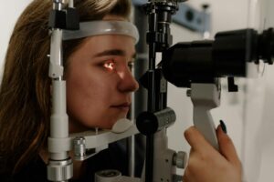 A woman undergoing an eye examination using a slit lamp in a modern clinic setting.