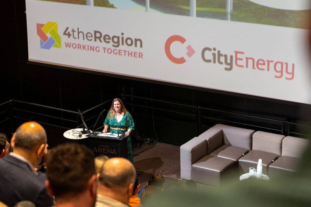 A woman speaking to an audience at a lectern.