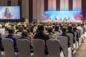 Rear view of Audience listening Speakers on the stage in the con