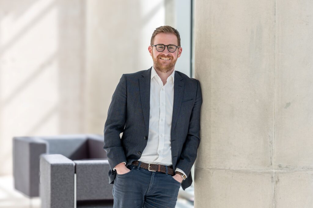 Andrew McGlashan, Corporate Partner at Acuity Law leaning against a wall.