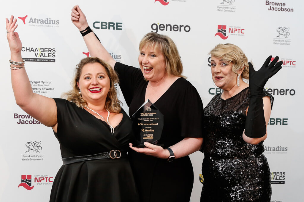 Three woman holding an award at an award show