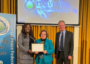 Bernie Davies receives Ambassador for Peace Award from Margaret Ali and Robin Marsh of Universal Peace Federation