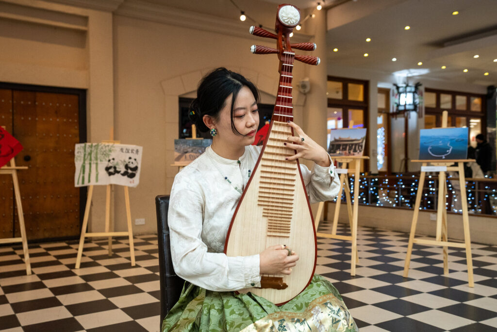 Woman playing a traditional wooden instrument