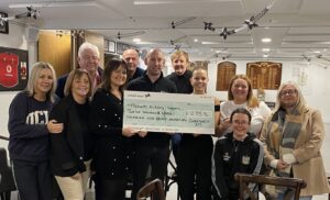 Popham Kidney Support CEO, Joanne Popham (center-left) & Administrator, Ava Houston-Phillips (center-right), with Cwmtwrch Rugby Club committee members.