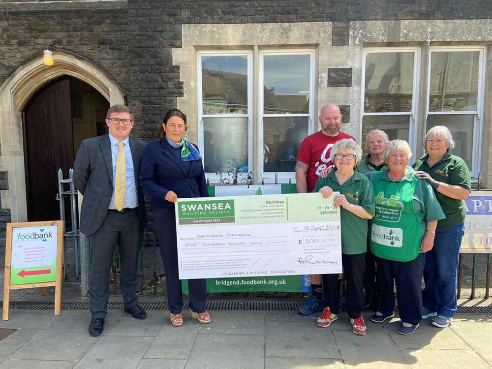 David Osterland, Cowbridge Branch Manager and Vicy Toutt, cashier at Cowbridge branch hand check to volunteers at Bridgend Foodbank