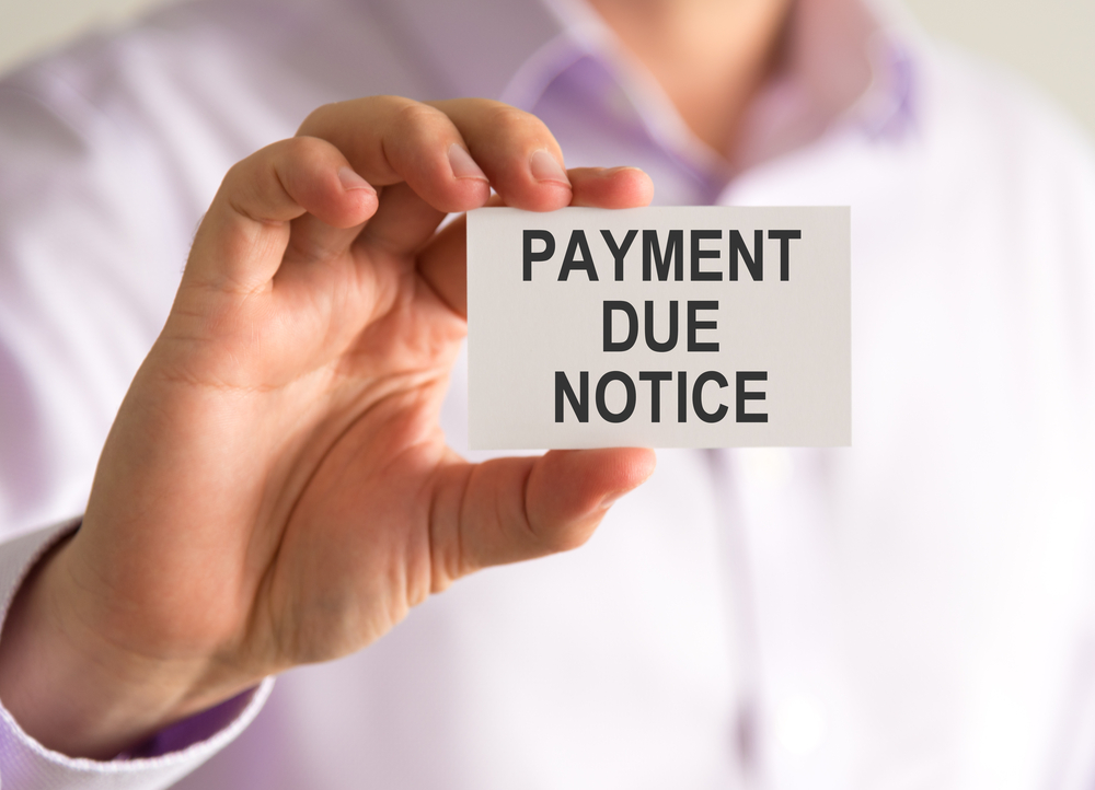 Businessman holding a card with PAYMENT DUE NOTICE message