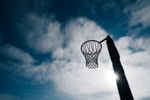 Netball goal ring and net against a blue sky and clouds at Hagle