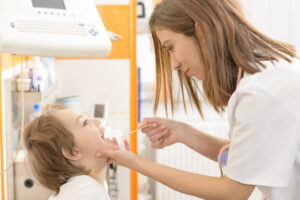 Cute boy being checked in throat