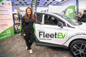 Hannah Williams stood in front of a branded FleetEV car.