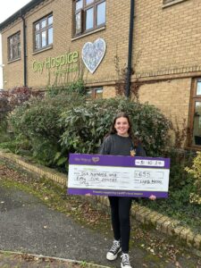 Lyra presents a cheque to City Hospice for her 2024 fundraising as she reaches £2000 in total