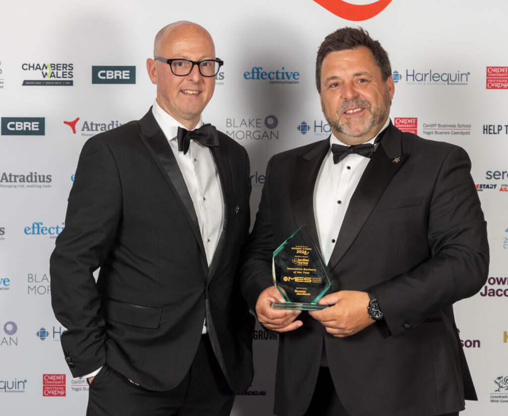 Two people standing with an award