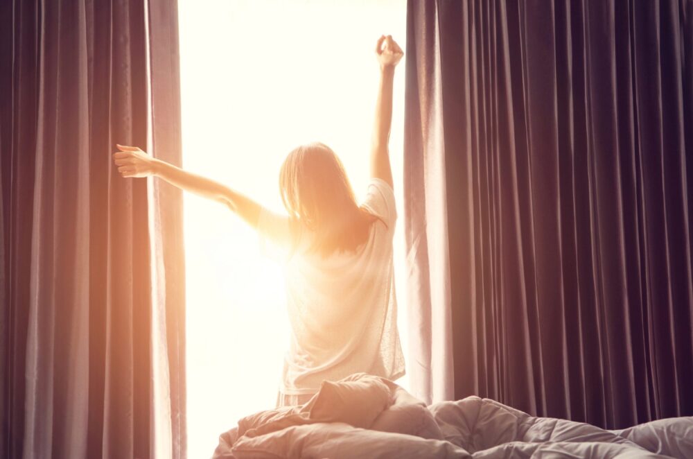 Woman stretching near bed after wake up