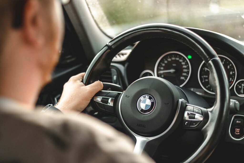 person driving bmw car during daytime