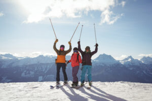 celebrating-skiers-standing-snow-covered-mountain