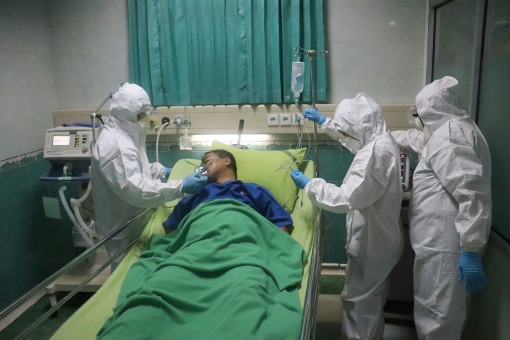 man in white scrub suit lying on hospital bed