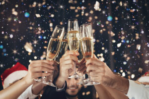 happy-new-year-clinking-glasses-champagne-hands-bright-lights-background