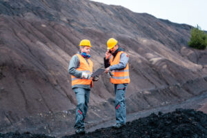 Workers in open-cast mining operation pit