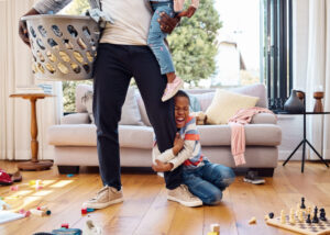 Shot of a little boy throwing a tantrum while holding his parent's leg at home