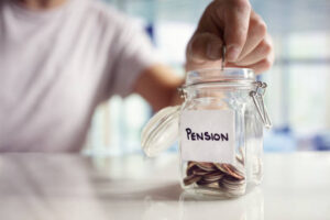 A person putting some money into a jar labelled 'Pension'