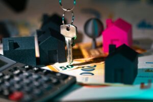 A calculator, keychain, and house model on a table