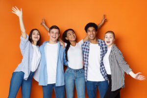 students-having-fun-orange-studio-background