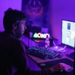 a man sitting in front of a computer monitor
